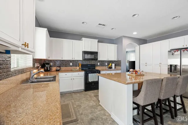 a kitchen with a sink a stove and chairs
