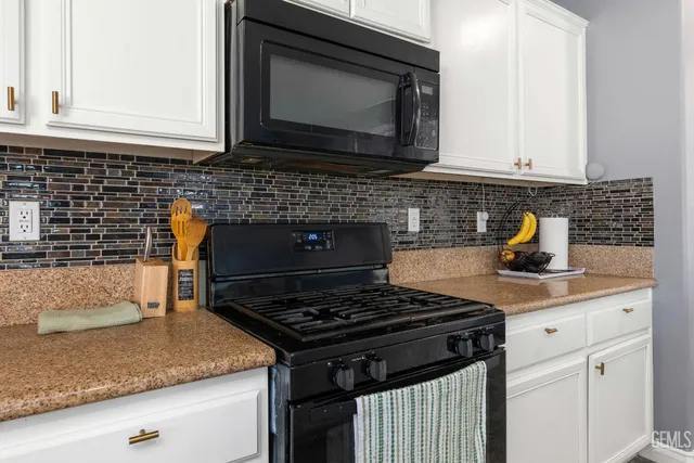 a kitchen with granite countertop a stove sink and cabinets