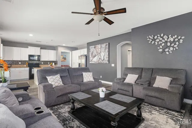 a living room with furniture kitchen view and a chandelier