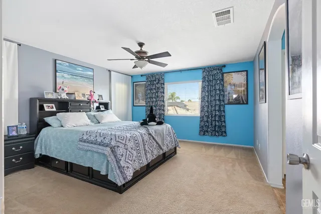 a spacious bedroom with a bed dresser and window