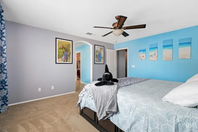 a bedroom with a bed and a painting on the wall