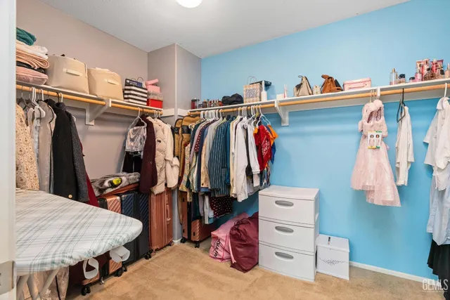 a view of walk in closet with clothes and shoes