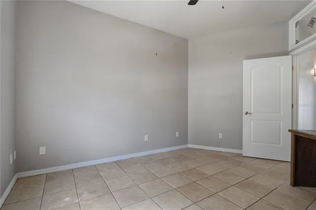 an empty room with windows fireplace and wooden floor
