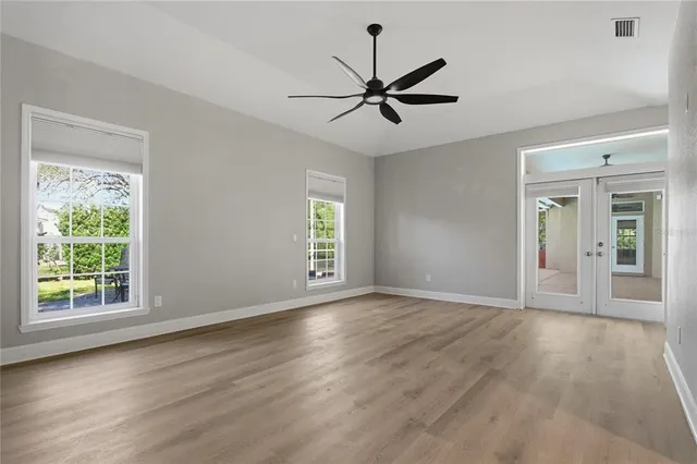 an empty room with a window and a fan