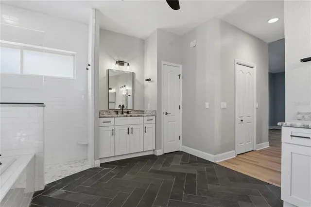 a bathroom with a granite countertop toilet sink and mirror