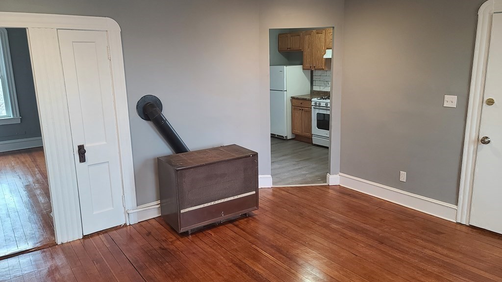 672 2nd Street Fall River, MA 02721 - Photo 12 of 16 an empty room with wooden floor and a window
