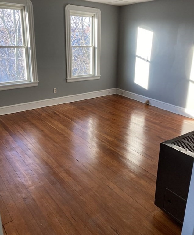 672 2nd Street Fall River, MA 02721 - Photo 3 of 16 an empty room with wooden floor and windows