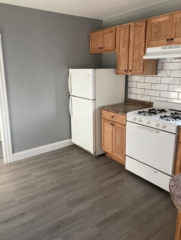 672 2nd Street Fall River, MA 02721 - Photo 4 of 16 a kitchen with wooden cabinets and white appliances