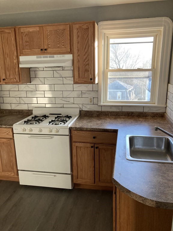 672 2nd Street Fall River, MA 02721 - Photo 5 of 16 a kitchen with granite countertop white cabinets and a stove with wooden floor