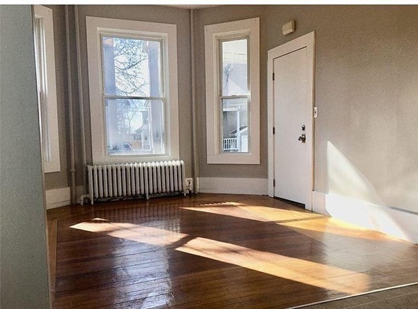 672 2nd Street Fall River, MA 02721 - Photo 7 of 16 an empty room with wooden floor and windows