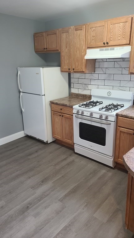 672 2nd Street Fall River, MA 02721 - Photo 9 of 16 a kitchen with a stove a microwave and a refrigerator