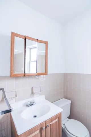 a bathroom with a sink a toilet and mirror