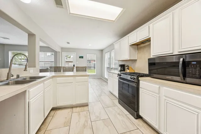 a large kitchen with cabinets stainless steel appliances and a counter space