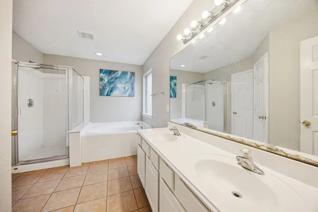 a spacious bathroom with a tub sink and mirror