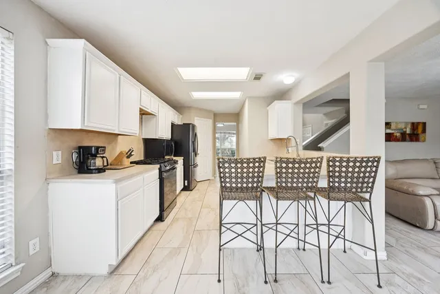 a kitchen with stainless steel appliances granite countertop a stove a sink a dining table and chairs