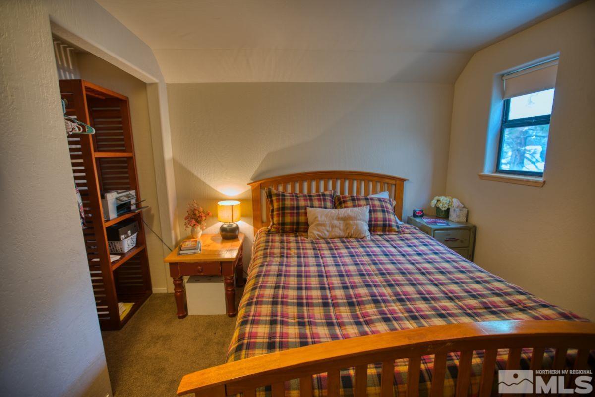 313 Tramway Drive, Unit 26 Stateline, NV 89449 - Photo 13 of 19 a bedroom with a bed and a book shelf