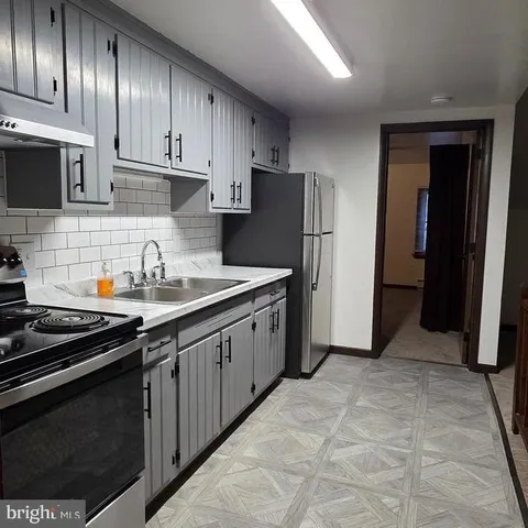 a kitchen with stainless steel appliances a sink stove and refrigerator