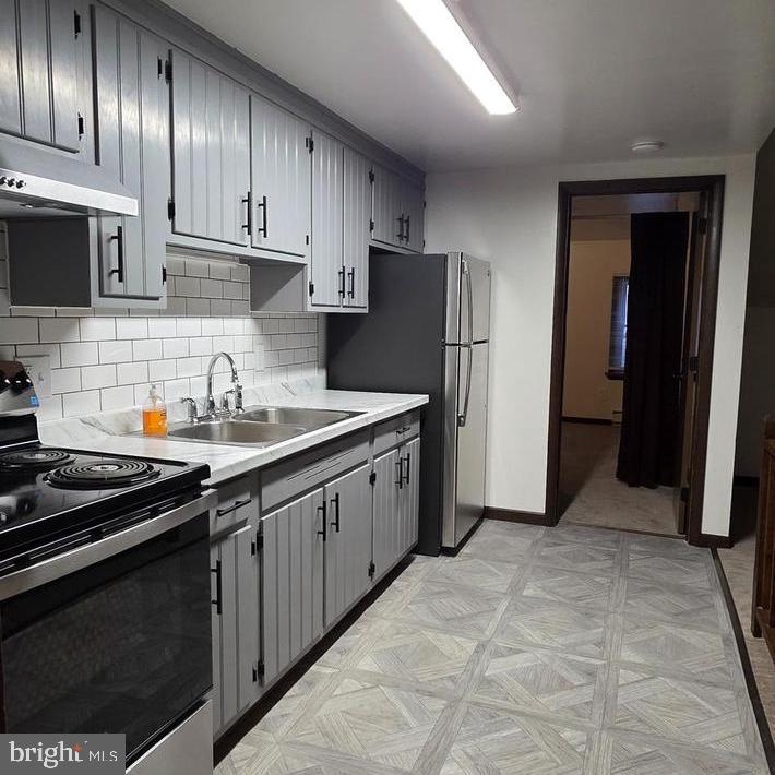 a kitchen with stainless steel appliances a sink stove and refrigerator
