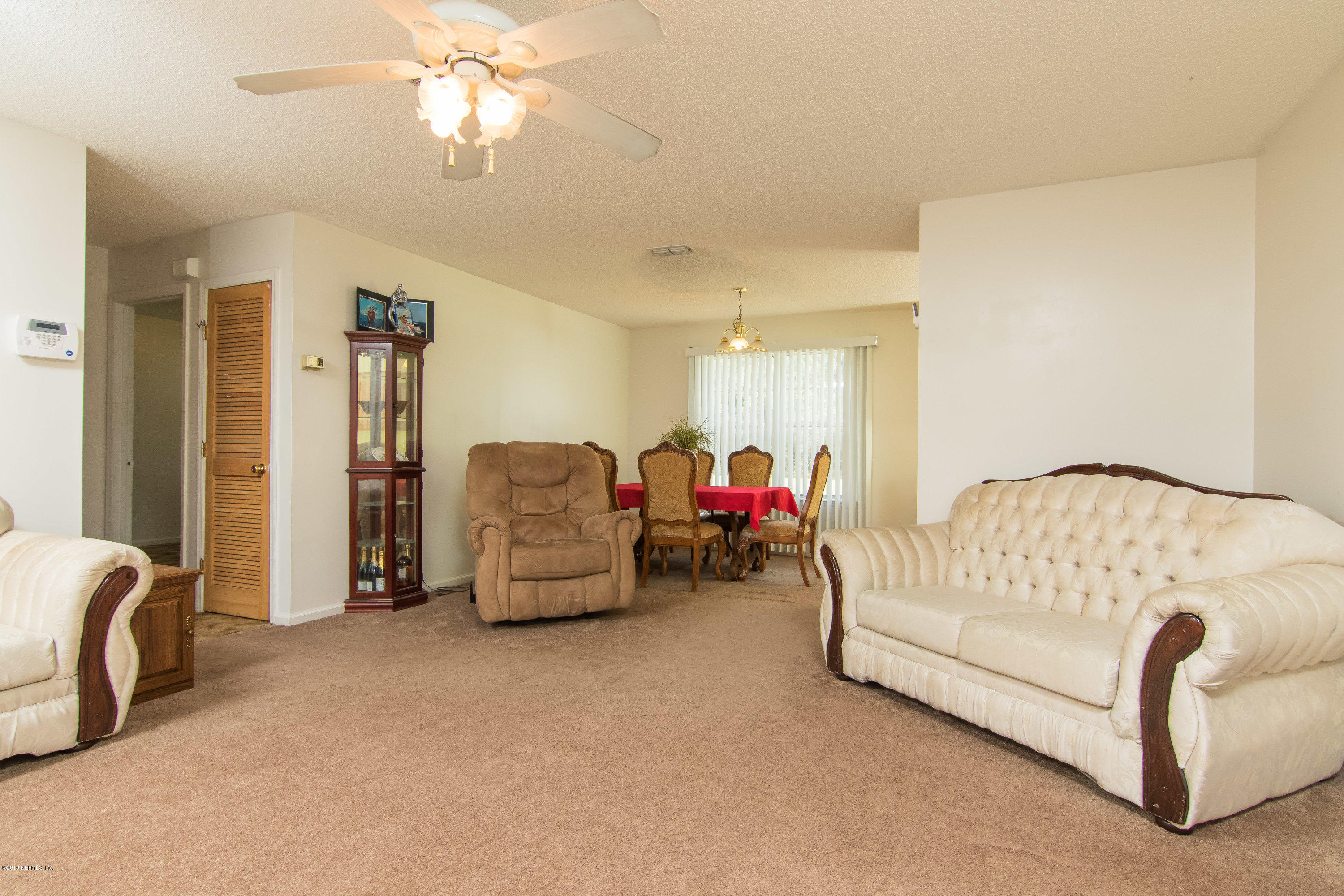 6345 Armstrong Road Elkton, FL 32033 - Photo 13 of 26 a living room with furniture and a chandelier