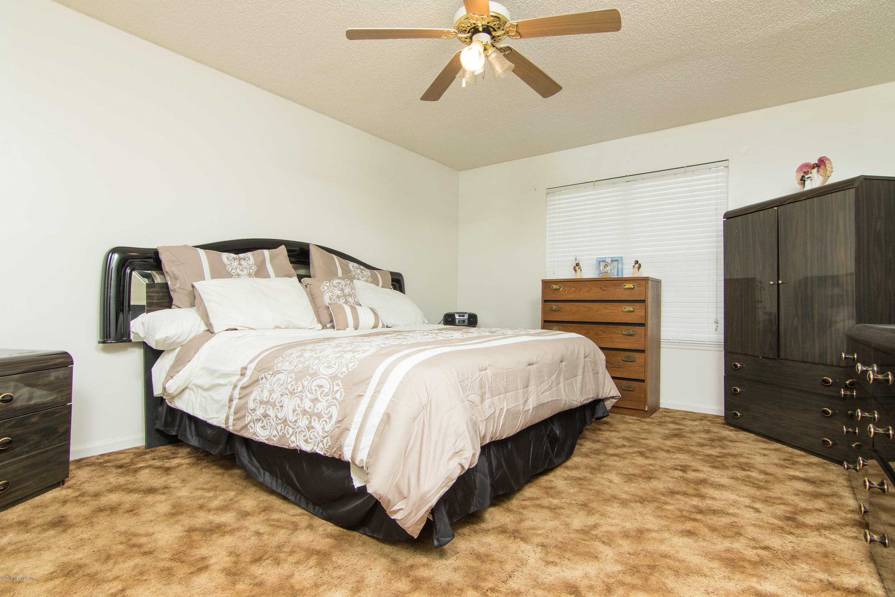 6345 Armstrong Road Elkton, FL 32033 - Photo 15 of 26 a bedroom with a bed and a flat tv screen on dresser