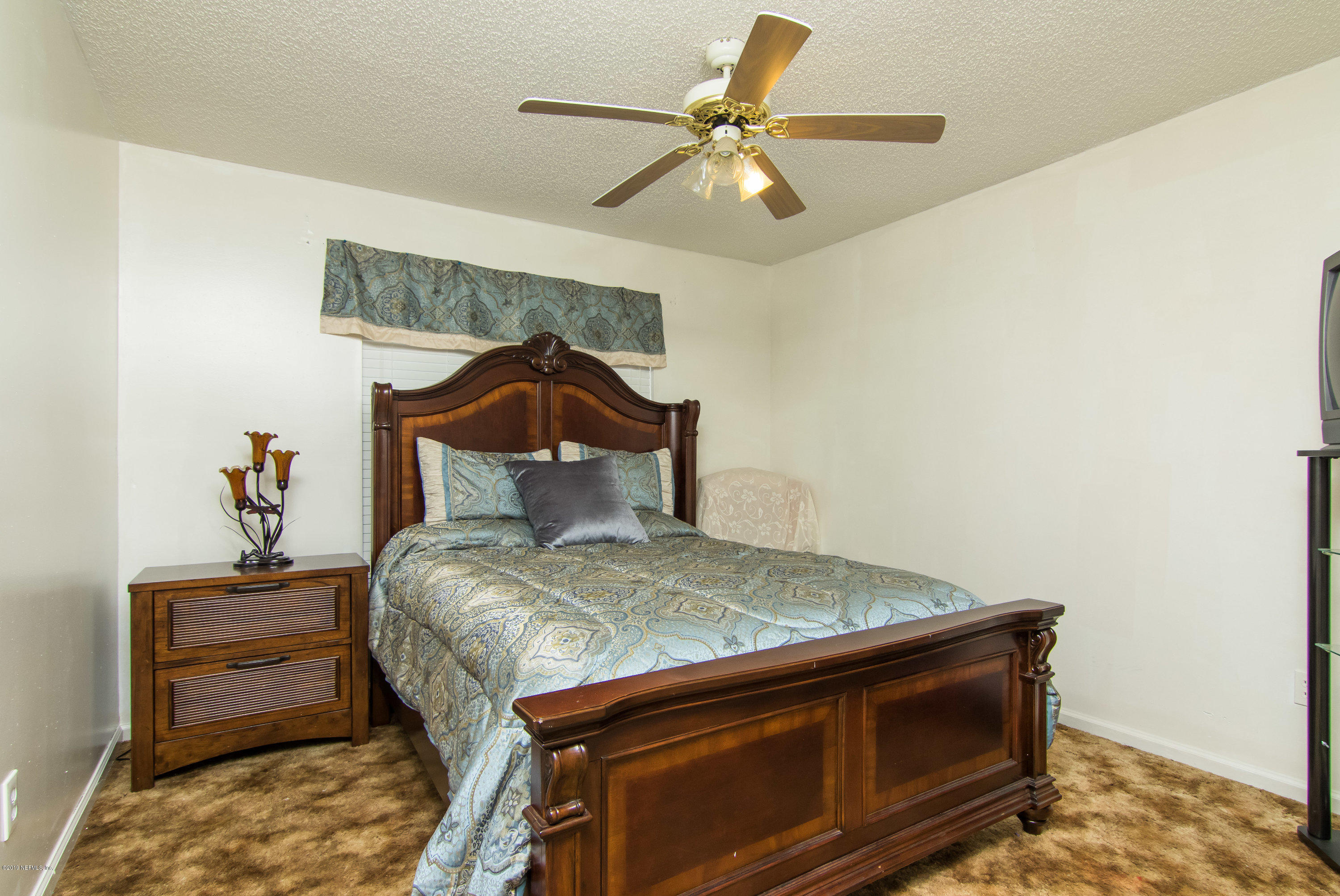 6345 Armstrong Road Elkton, FL 32033 - Photo 18 of 26 a bedroom with a bed and a chandelier