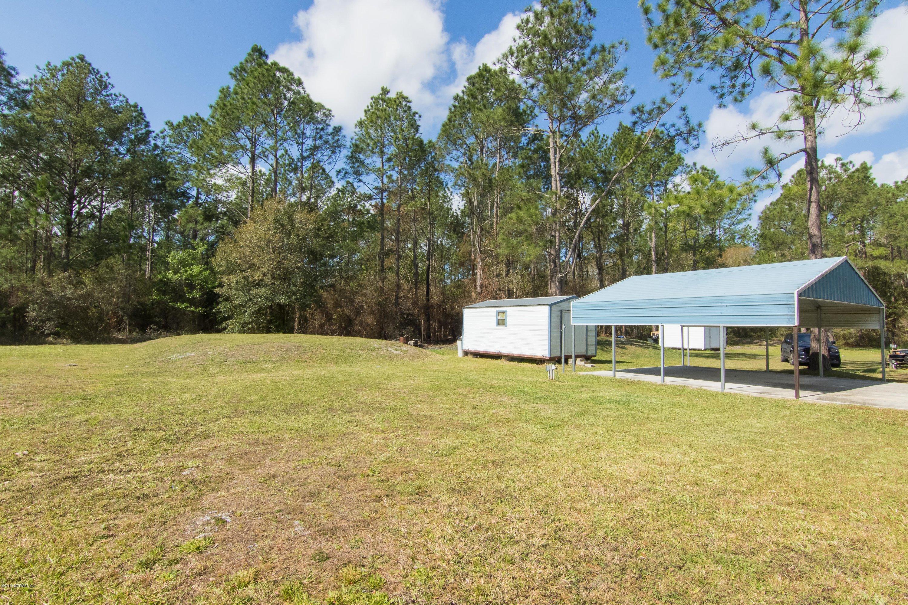 6345 Armstrong Road Elkton, FL 32033 - Photo 4 of 26 a house with trees in front of it