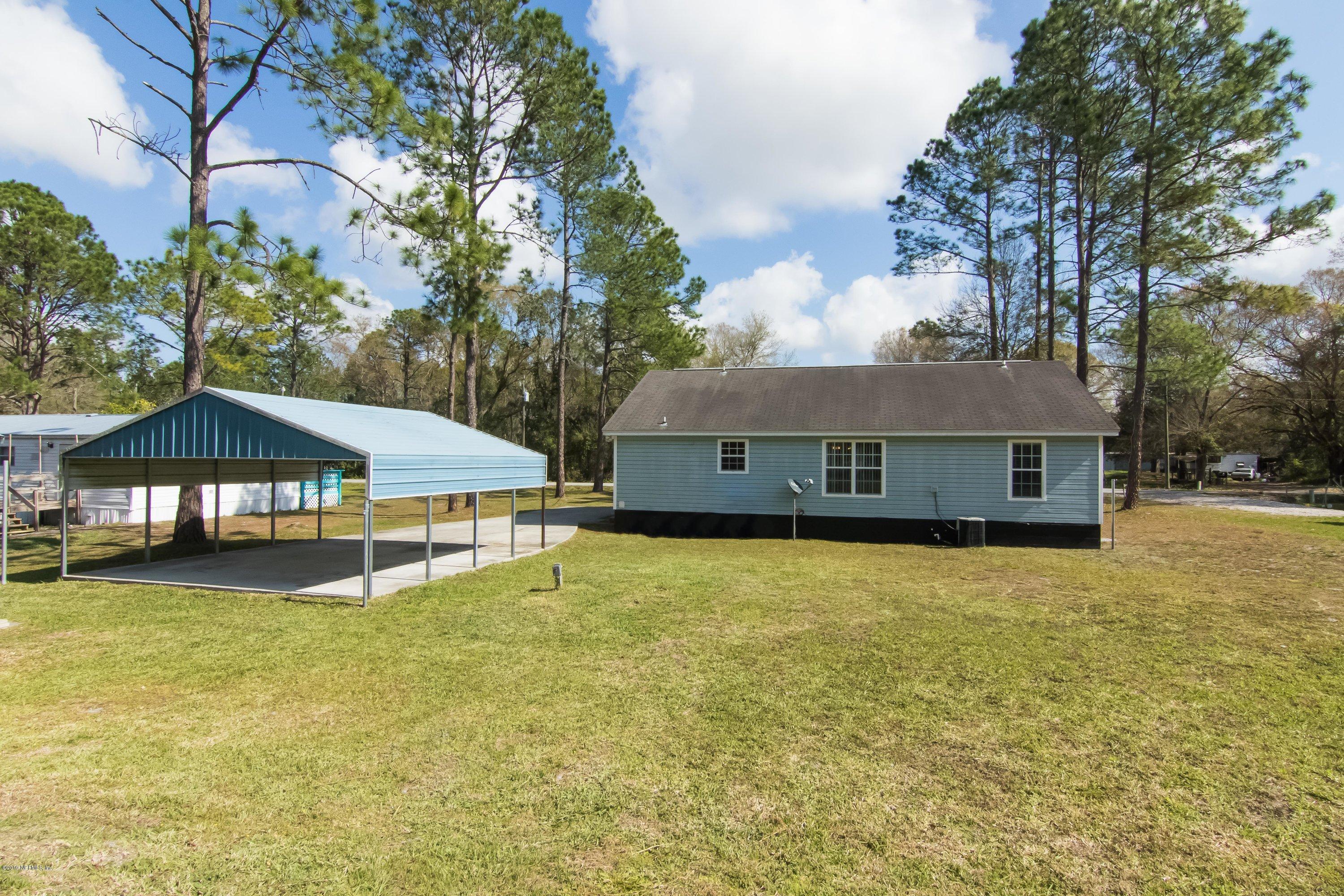 6345 Armstrong Road Elkton, FL 32033 - Photo 6 of 26 a house with a garden and trees