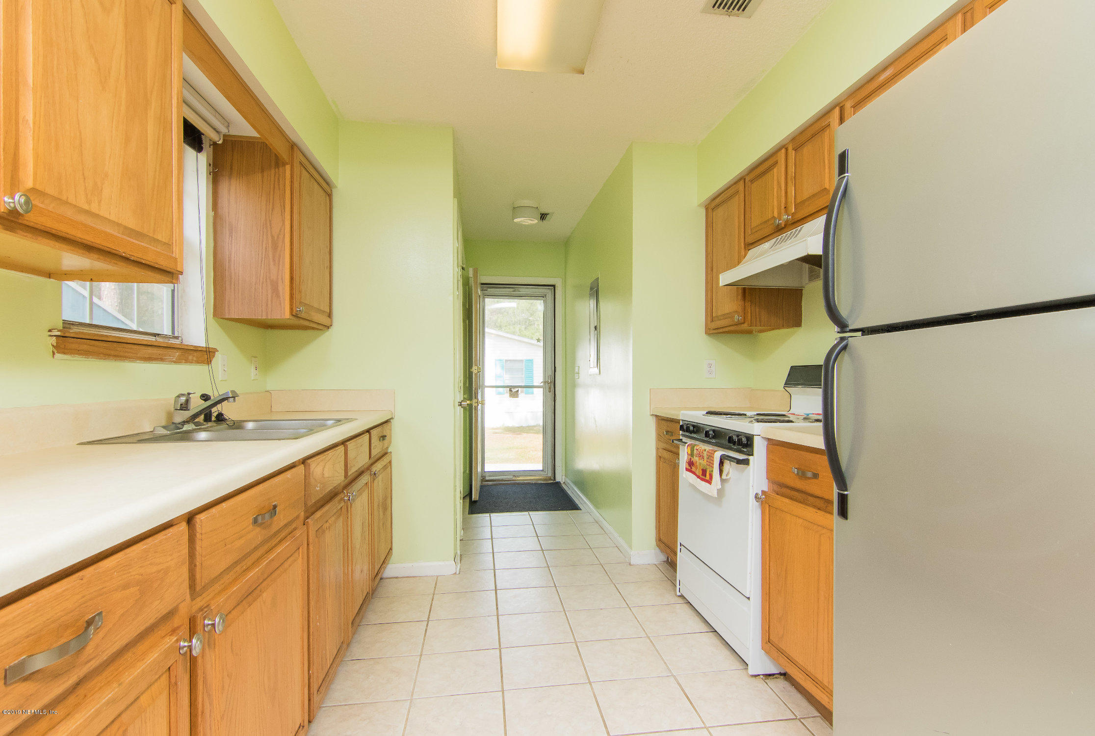 6345 Armstrong Road Elkton, FL 32033 - Photo 9 of 26 a kitchen with granite countertop a sink and a refrigerator