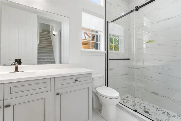 a bathroom with a sink a toilet and shower