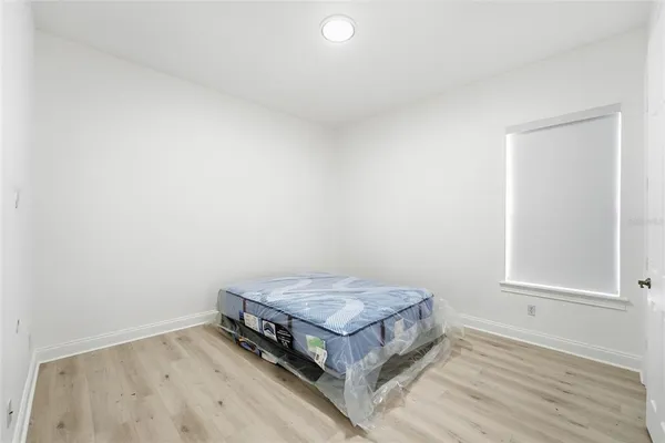a room with a bed and wooden floor