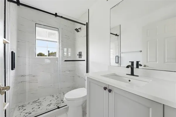 a bathroom with a sink toilet a mirror and shower
