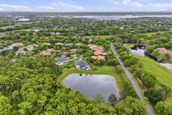 an aerial view of residential houses with outdoor space and trees