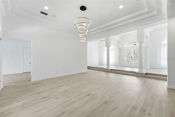 an empty room with wooden floor and mirror