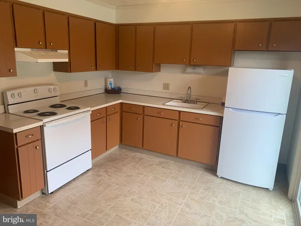 a kitchen with a sink a stove and a refrigerator