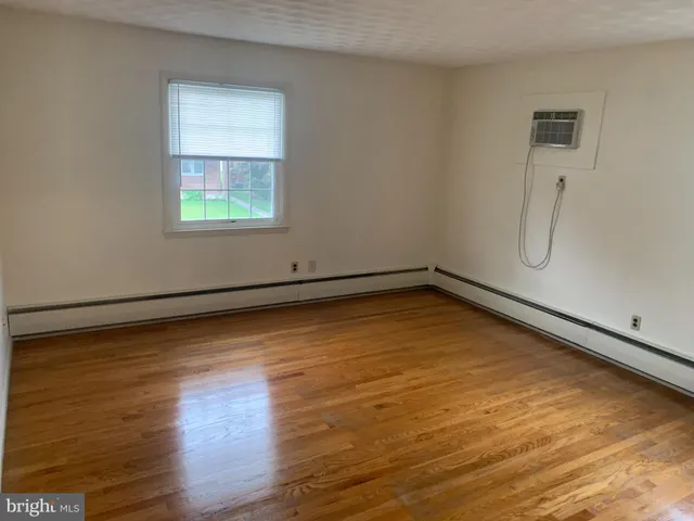 a view of a room with wooden floor and window