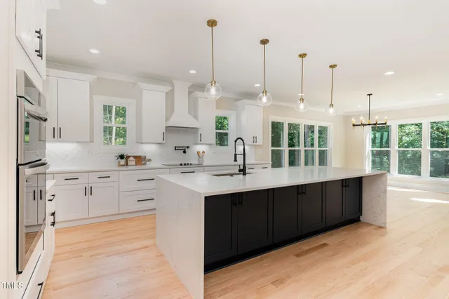 a large kitchen with kitchen island a sink stainless steel appliances and cabinets