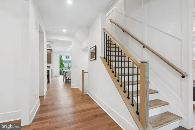a view of a hallway with wooden floor and stairs