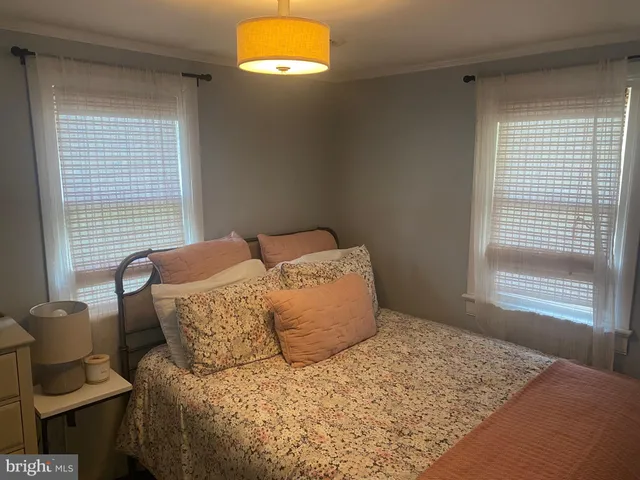 a large bed sitting in a bedroom next to a window
