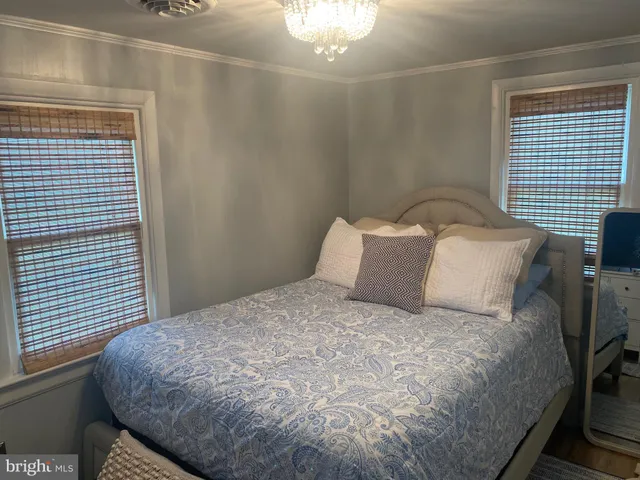 a large bed sitting in a bedroom next to a window and a flat screen tv