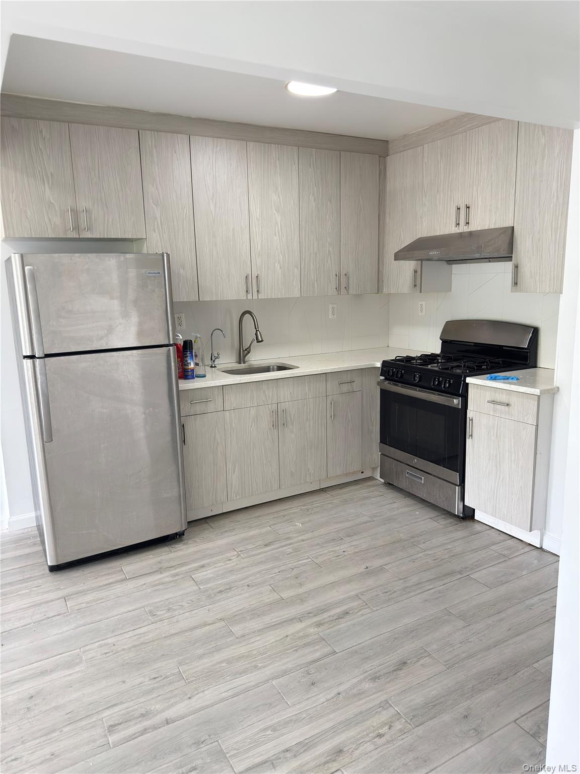 49-10 111th Street, Unit 3A Queens, NY 11368 - Photo 5 of 8 a kitchen with a refrigerator sink and cabinets