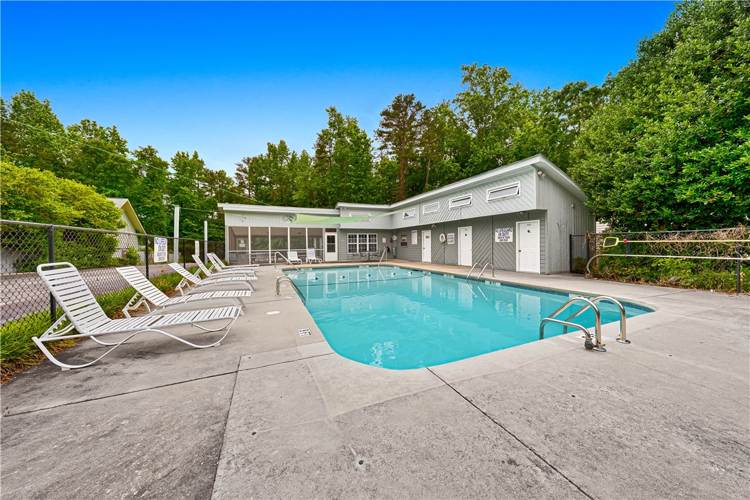 281 Cherokee Drive Fair Play, SC 29643 - Photo 22 of 26 A sparkling community pool invites relaxation, set against a backdrop of mature trees and a screened-in recreation building.