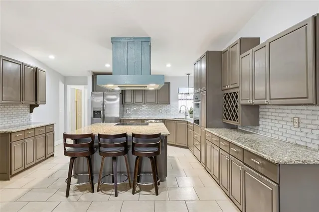 a kitchen with stainless steel appliances kitchen island granite countertop a sink and cabinets