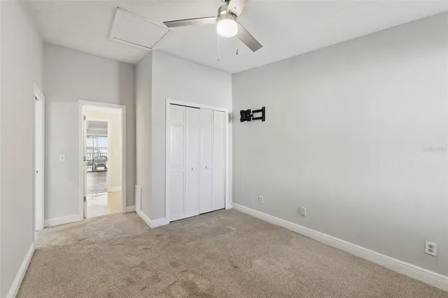 an empty room with closet and a ceiling fan