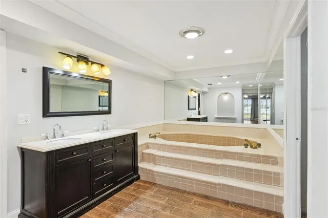 a spacious bathroom with a tub sink and mirror
