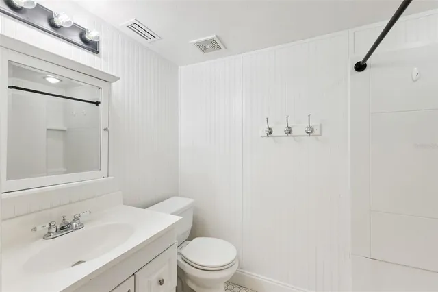 a bathroom with a sink a toilet and a mirror