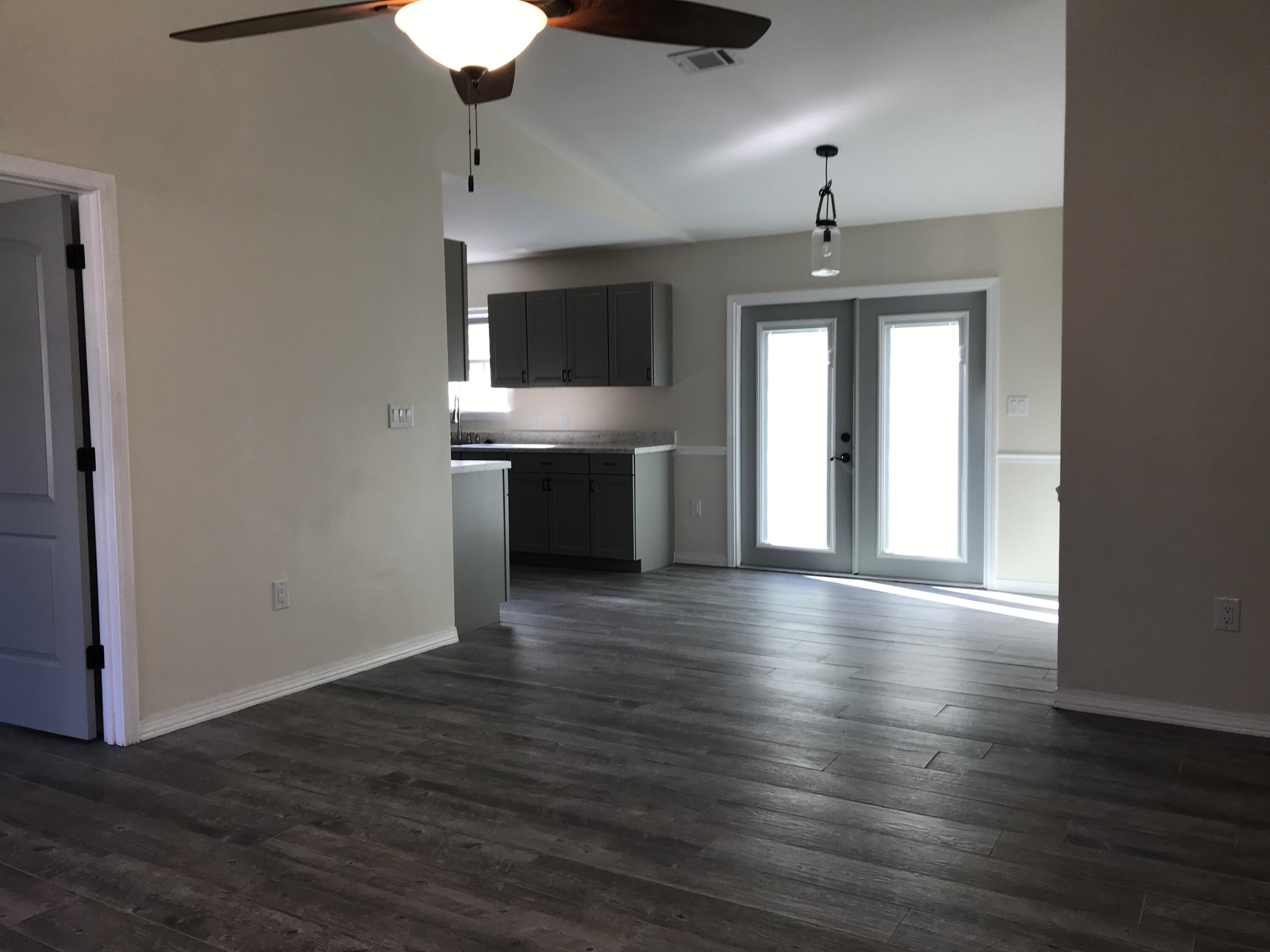 113 Oak Terrace Drive Crestview, FL 32539 - Photo 4 of 21 a view of a kitchen with a stove wooden floor and a kitchen space