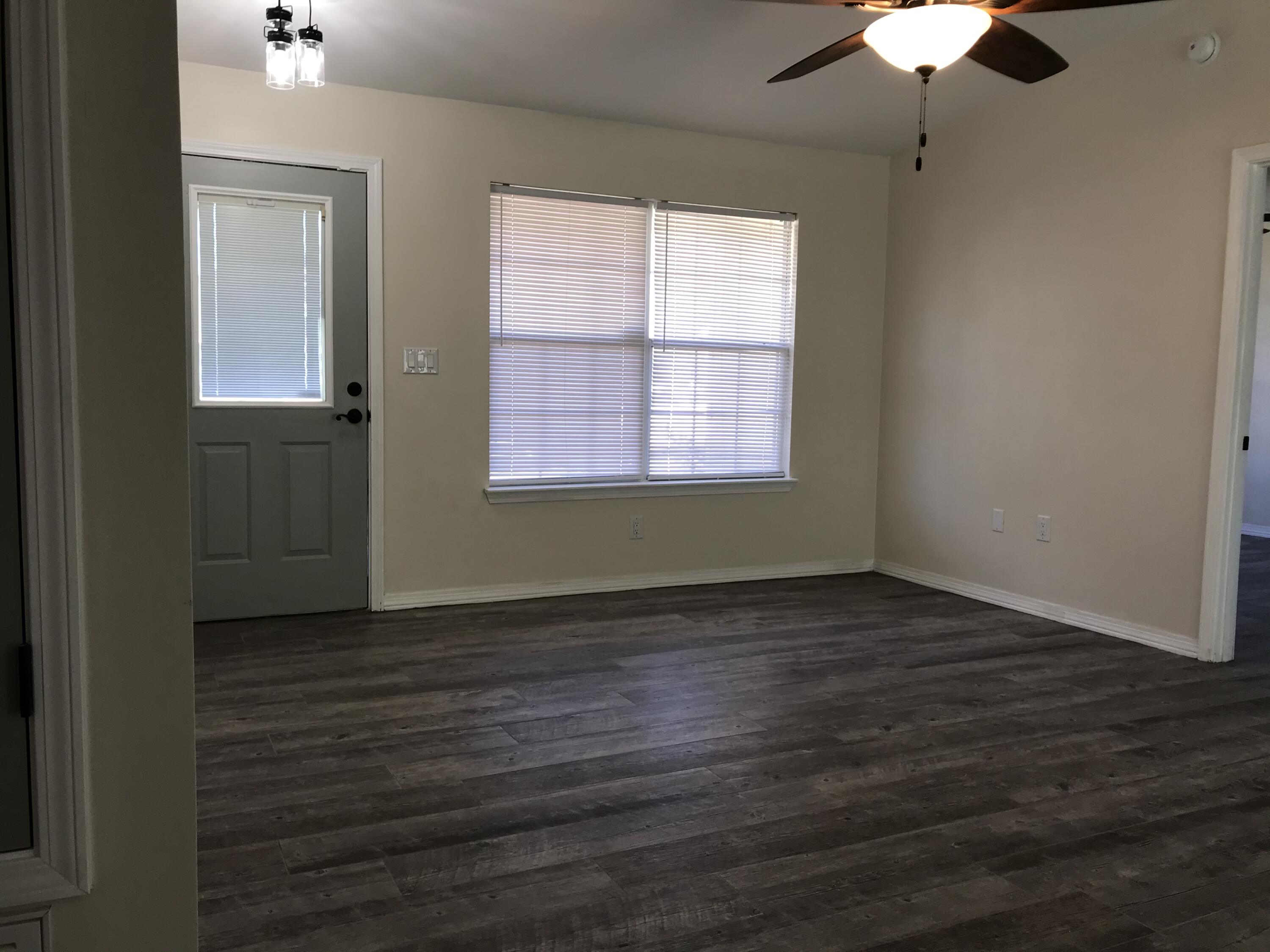 113 Oak Terrace Drive Crestview, FL 32539 - Photo 5 of 21 an empty room with wooden floor chandelier fan and windows