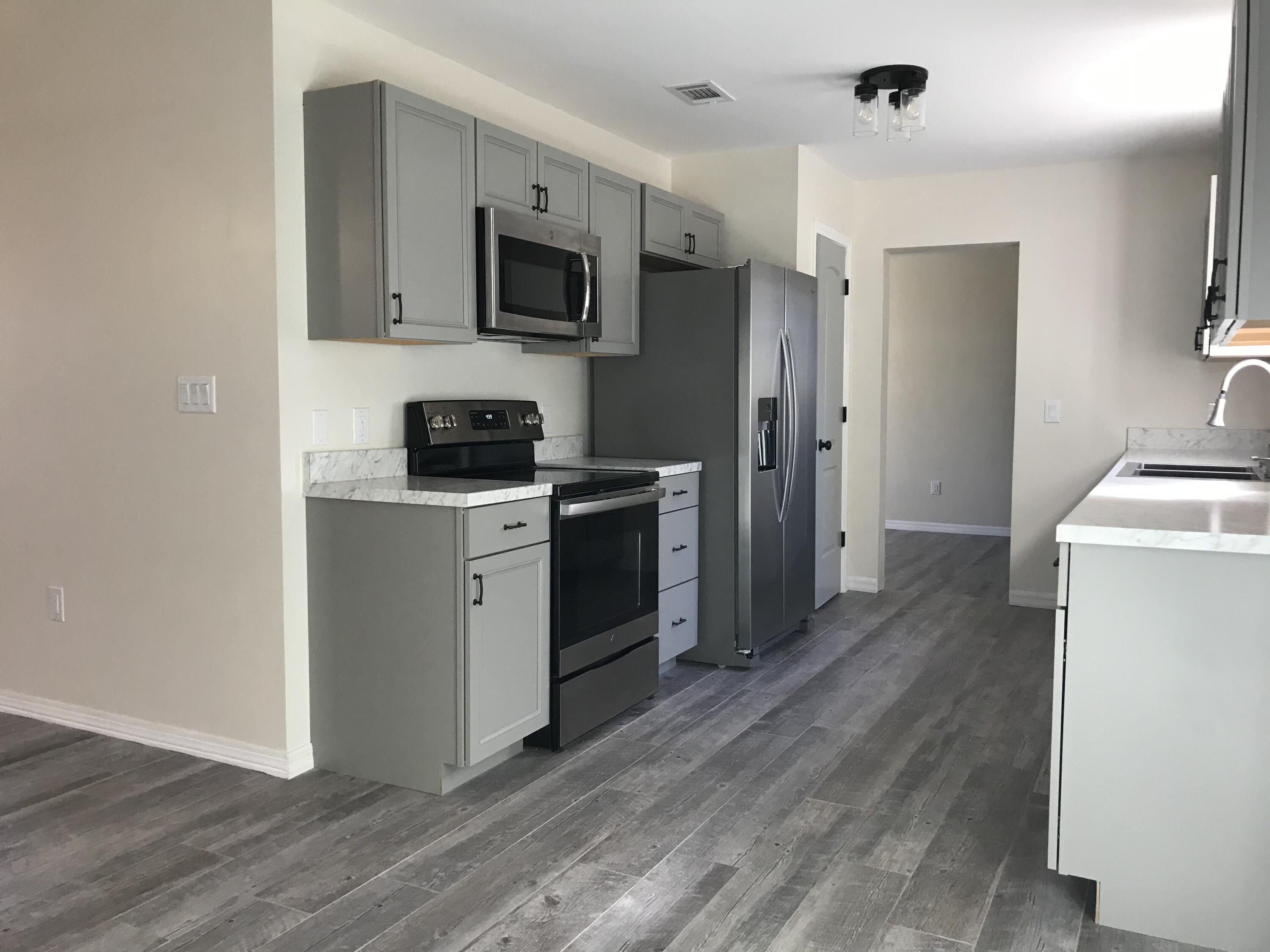 113 Oak Terrace Drive Crestview, FL 32539 - Photo 7 of 21 a kitchen with stainless steel appliances a sink cabinets and wooden floor