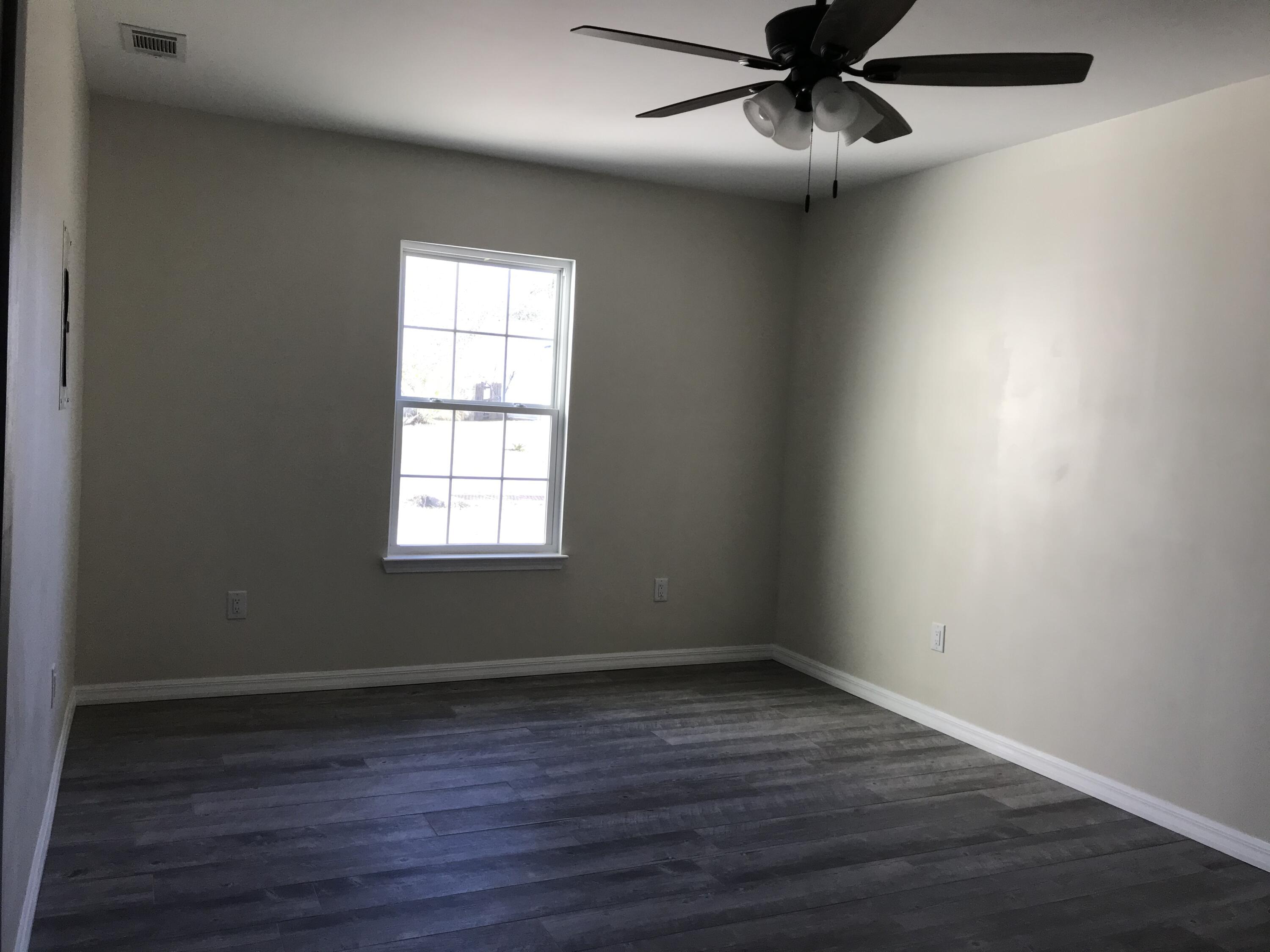 113 Oak Terrace Drive Crestview, FL 32539 - Photo 10 of 21 a view of an empty room with wooden floor and a window