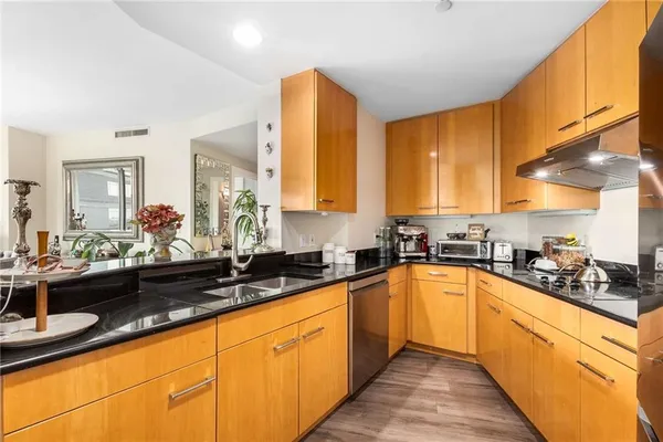 a large kitchen with granite countertop a sink and cabinets